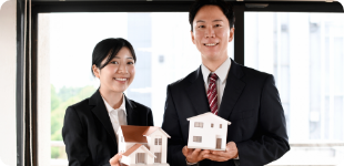 家の模型を持つスタッフの写真