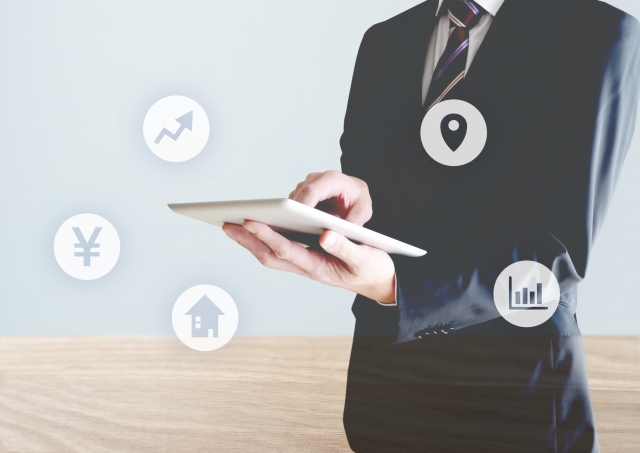 タブレットを操作するスーツの男性